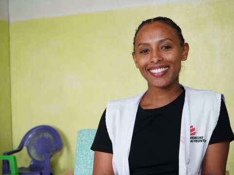 En kvinna i Läkare Utan Gränser-väst ler mot kameran.