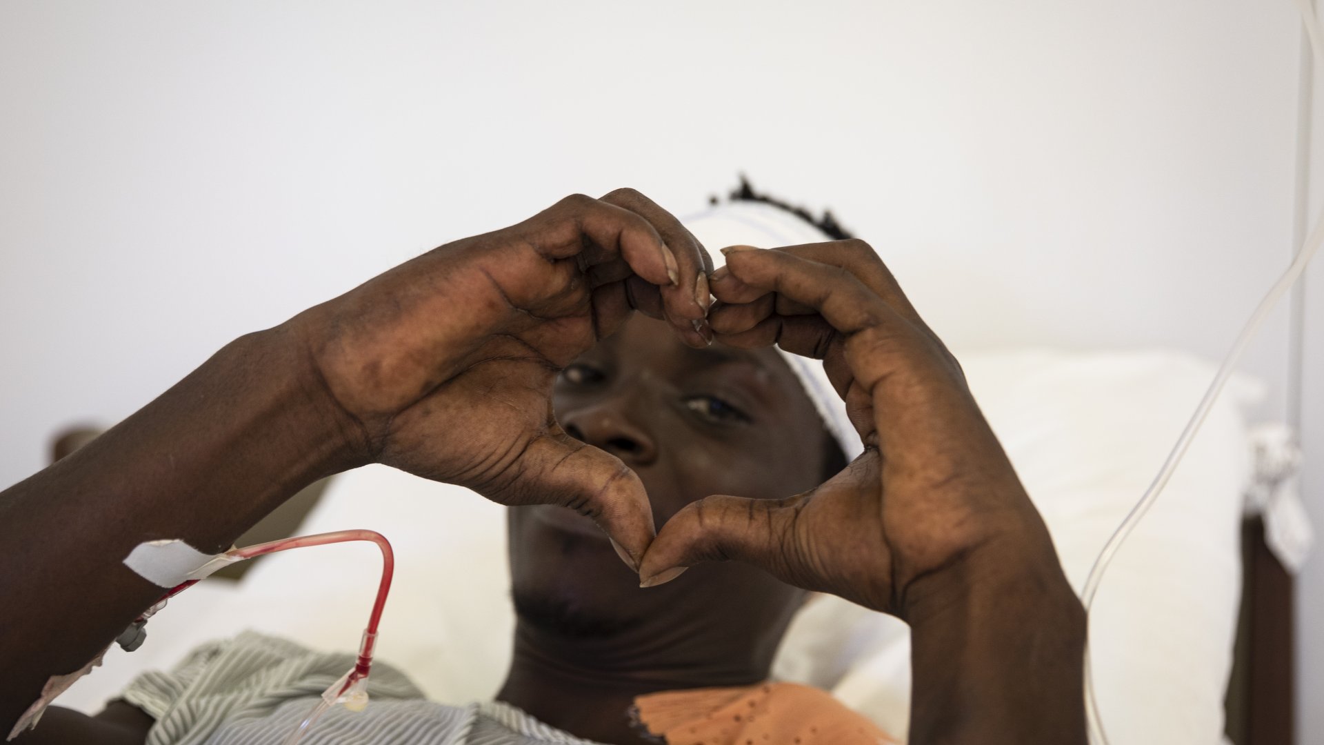 En man formar ett hjärta med sina händer på vårt sjukhus i Tabarre, Haiti.